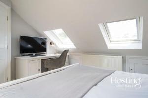 a bedroom with a bed and a desk with a television at Station House in Marlow +17 photos