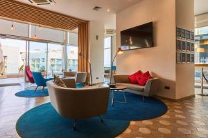 a living room with a couch and chairs and a tv at Holiday Inn Express - Malta by IHG in St. Julianʼs