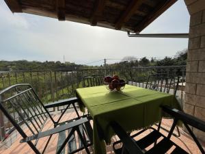 a green table with a bowl of fruit on a balcony at Apartman Ana in Rijeka