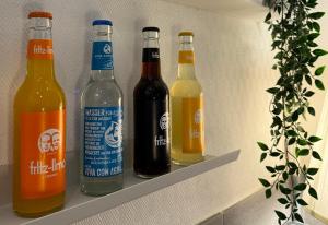 four bottles of beer sitting on a shelf at Hotel Kieler Hof am Hauptbahnhof - Hamburg Central Station in Hamburg