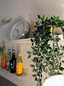 a clock and a potted plant on a shelf with bottles at Hotel Kieler Hof am Hauptbahnhof - Hamburg Central Station in Hamburg