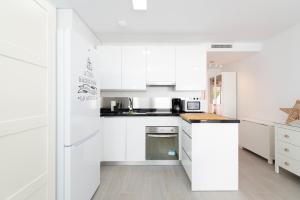 貝納加爾彭塔的住宿－DREAMY BEACH PENTHOUSE，白色的厨房配有白色橱柜和电器