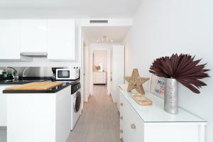 a kitchen with white cabinets and a counter top at DREAMY BEACH PENTHOUSE in Torre de Benagalbón