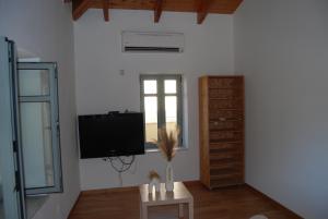 a living room with a flat screen tv on the wall at Casa Edelsy Bienvenid@s a un oasis de tranquilidad Descubre el encanto de Creta desde nuestra casa de ensueño! Tranquilidad, comodidad y elegancia. Explora Creta desde nuestro acogedor hogar Una escapada inolvidable te espera. in Neápolis