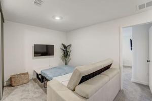 a white living room with a couch and a tv at Kissimmee Modern 3BR Home With a pool & Close to Beach in Kissimmee