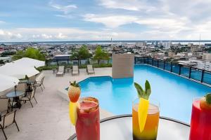 een uitzicht vanaf het dak van een hotel met drankjes op een tafel bij Apto Executivo no Intercity in Manaus