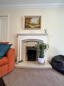 a living room with a fireplace with a painting above it at Ferienhaus für 6 Personen ca 100 qm in Crianlarich, Schottland Loch Lomond and the Trossachs Nationalpark in Crianlarich