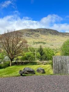 uma vista para uma montanha com uma cerca e rochas em Ferienhaus für 6 Personen ca 100 qm in Crianlarich, Schottland Loch Lomond and the Trossachs Nationalpark em Crianlarich
