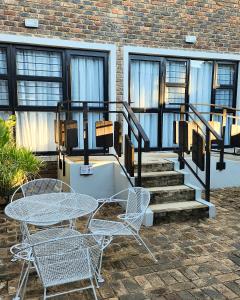 patio ze stołem, krzesłami i schodami w obiekcie Waterlily Cove Guesthouse w mieście Pretoria