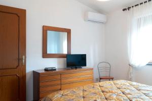 a bedroom with a bed and a dresser with a television at Casa Silvana in Vico Equense