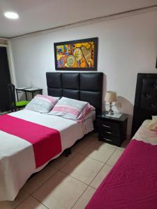 um quarto com duas camas e um quadro na parede em HOTEL GALICIA PLAZA em Manizales