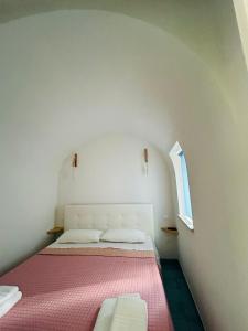 a small bedroom with two beds and a window at Sun Home in Vietri