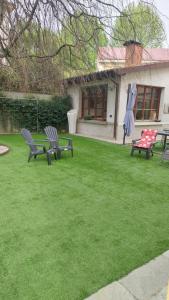 two benches sitting in a yard with green grass at Villa Lina in Cremona