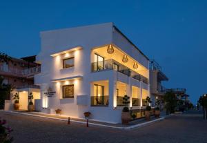 a white building with lights on it at night at Alexandrion Appartements Down Town in Sarti