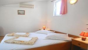- 2 lits jumeaux dans une chambre avec fenêtre dans l'établissement Schöne Ferienwohnung in Baška Voda mit Garten, à Baška Voda