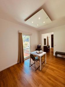 een lege woonkamer met een tafel en een raam bij VALE MAR Guest in Ribeira Brava