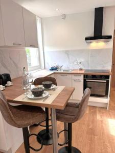 een keuken met een houten tafel en stoelen bij Flat 2beds Bellegarde in Bellegarde-sur-Valserine