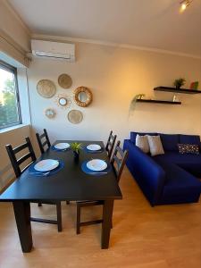 salon ze stołem i niebieską kanapą w obiekcie Columbano's House - Apartment in Central Lisbon w Lizbonie