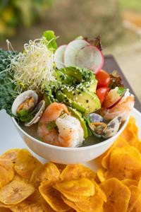 a plate of food with shrimp and vegetables and chips at Hotel Rivel - Restaurant & Nature Retreat in Turrialba