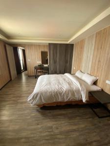 1 dormitorio con 1 cama grande y escritorio en Tai Shinu Hotel en Douliu