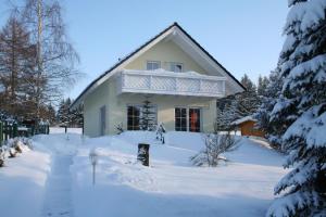 una casa ricoperta di neve con un cortile di Ferienhaus Vogtlandresidenz a Beerheide