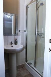 W łazience znajduje się umywalka i prysznic. w obiekcie 4 Sisters Inn w mieście Theydon Bois