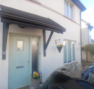 una casa bianca con un tendone sopra una porta di Cobh Rambler a Cobh