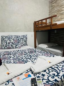 een slaapkamer met 2 stapelbedden en een afstandsbediening bij Pousada Ilha Bela in Maceió