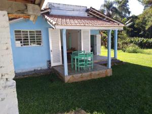a house with a table and chairs on a porch at Joanopolis Inn - Mantiqueira 1 in Joanópolis