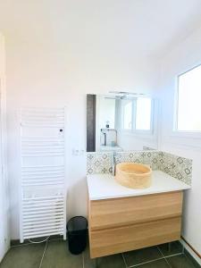 łazienka z umywalką i drewnianą miską na ladzie w obiekcie Magnifique appartement au coeur des volcans w mieście Blanzat