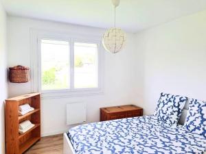 sypialnia z niebiesko-białym łóżkiem i oknem w obiekcie Magnifique appartement au coeur des volcans w mieście Blanzat