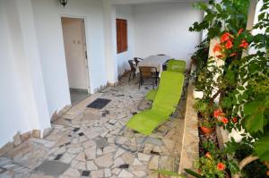 un patio con tavolo, sedie e fiori di Ferienwohnung für 4 Personen 1 Kind ca 70 qm in Poljica bei Trogir, Dalmatien Kaštela und Umgebung a Poljica