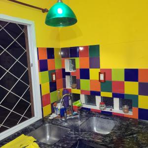 eine farbenfrohe Küche mit einem Waschbecken und grünem Licht in der Unterkunft Pequinos in Strobel