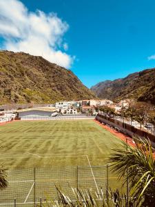 a tennis court in front of a mountain at VALE MAR Guest in Ribeira Brava