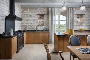 eine Küche mit Holzschränken und einer Steinwand in der Unterkunft Luxuriöse Villa Elena Exclusive mit Privatem Pool und Panoramablick in Ladići