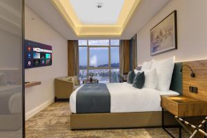 a hotel room with a bed and a large window at ِAluya Hotel in Jeddah