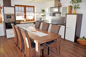 eine Küche mit einem Holztisch mit Stühlen und einem Kühlschrank in der Unterkunft Ferienwohnung in Sellin mit Grill, Terrasse und Garten in Ostseebad Sellin