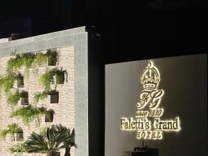 a sign for a hotel with a crown on it at Faletti’s Grand MM Alam Road in Lahore
