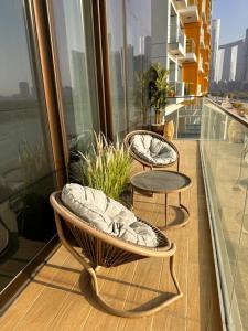 two chairs and a table on a balcony at Enjoy Luxury Condo with Sea View in Abu Dhabi