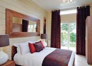 A bed or beds in a room at Roydon Marina Village 