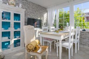 a white dining room with a white table and chairs at Ferienwohnung für 2 Personen ca 50 qm in Orebić, Dalmatien Süddalmatien in Orebić