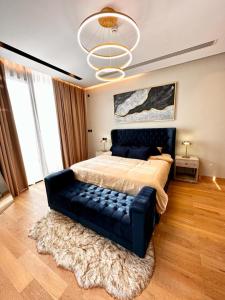 a bedroom with a large bed with a blue couch at Enjoy Luxury Condo with Sea View in Abu Dhabi