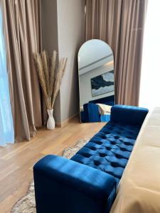 a living room with a blue couch and a mirror at Enjoy Luxury Condo with Sea View in Abu Dhabi
