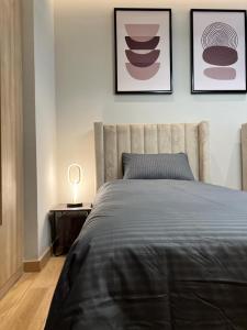 una camera con un letto e due quadri appesi al muro di Enjoy Luxury Condo with Sea View a Abu Dhabi