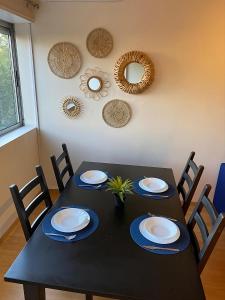 a black table with chairs and plates and mirrors at Columbano's House - Apartment in Central Lisbon in Lisbon