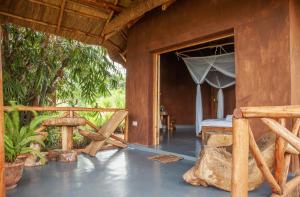 a room with a bed and an open door at Rutete Eco Lodge in Rwinkwavu