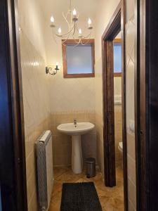 ein Badezimmer mit einem Waschbecken, einem WC und einem Kronleuchter in der Unterkunft Casa Vacanze Lappe in Pratola Peligna