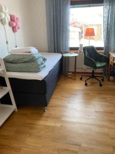 una camera con un letto e una sedia e una finestra di Eget hus i Vittjärv a Boden