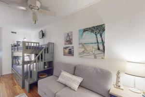 a living room with a couch and a spiral staircase at Starboard Tack 1A in Ocean City