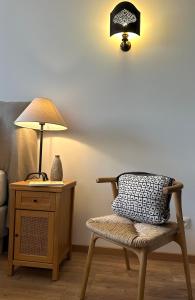 um quarto com uma cadeira, um candeeiro e uma almofada em l'Alceste em La Ciotat